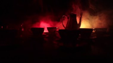 Kahve veya çay töreni kavramsal tema. Eski vintage Seramik çay veya kahve koyu tonlu arka plan ışık ve duman ile bardak sürahi ve şeker Kupası ile. Metin için boş yer. Kaymak vurdu