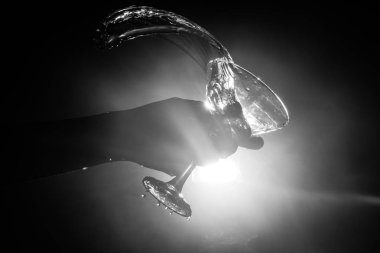 Martini kokteyl cam el koyu tonda dumanlı arka plan veya renkli kokteyl cam su sıçramalarına ve zeytin sıçramasına. Parti club eğlence. Karışık ışık. Seçici odak