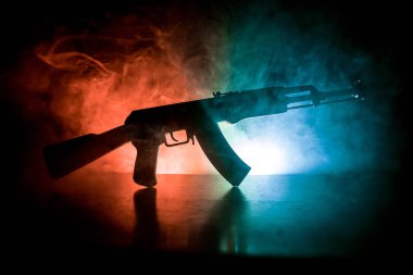 Saldırı tüfeği tonda sisli zemin üzerine silüeti. Savaş ya da antiterrorism kavramı. Rus askeri silah masada.