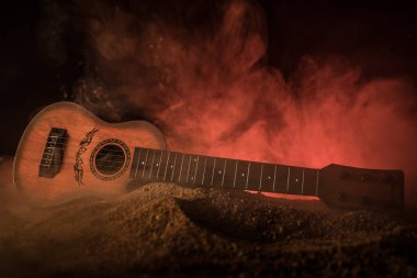Müzik konsepti. Akustik gitar ile kopya alanı dumanla ışık demeti altında karanlık bir arka plan üzerinde izole. Gitar telleri, yakın çekim. Seçici odak.