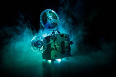 Eski stil film projektör, Natürmort, yakın çekim. Film projektör dramatik aydınlatma ve seçici odak ahşap bir zemin üzerine. Film ve eğlence kavramının