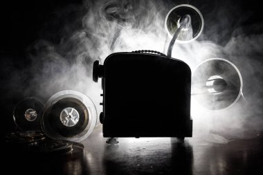 Eski stil film projektör, Natürmort, yakın çekim. Film projektör dramatik aydınlatma ve seçici odak ahşap bir zemin üzerine. Film ve eğlence kavramının