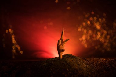 Cadılar Bayramı kavramı, yerden yükselen zombi el veya zombi el onun mezardan üzerinde koyu tonda sisli arka plan