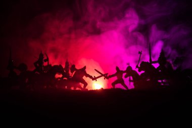 Süvari ve piyade ile ortaçağ savaş sahnesi. Siluetleri şekiller ayrı nesneler olarak mücadele koyu tonda sisli arka plan savaşçılar arasında. Gece sahne. Seçici odak
