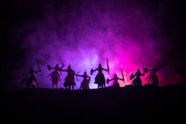 Süvari ve piyade ile ortaçağ savaş sahnesi. Siluetleri şekiller ayrı nesneler olarak mücadele koyu tonda sisli arka plan savaşçılar arasında. Gece sahne. Seçici odak