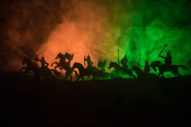 Süvari ve piyade ile ortaçağ savaş sahnesi. Siluetleri şekiller ayrı nesneler olarak mücadele koyu tonda sisli arka plan savaşçılar arasında. Gece sahne. Seçici odak