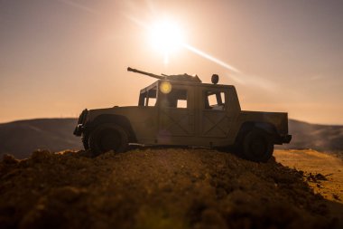 Gün batımı arka plan üzerinde askeri devriye arabası. Ordu savaş kavramı. Eylemde silahlı ve zırhlı silüeti. Dekore edilmiş. Seçici odak