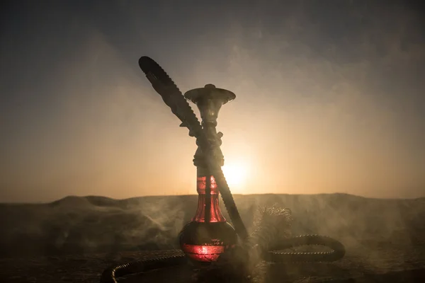 水ギセル 伝統的なアラビア語の水田はこ 直接日没ライト 屋外の写真 山背景や夕日を背景に水ギセルのシルエット 選択と集中 — ストック写真