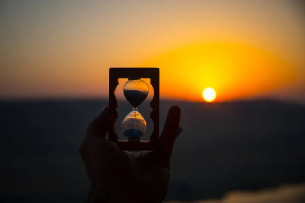 Conceito Passagem Vida Mão Segurando Ampulheta Com Fundo Céu Pôr — Fotografia de Stock