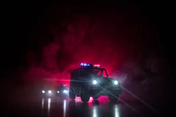 Police cars at night. Police car chasing a car at night with fog background. 911 Emergency response police car speeding to scene of crime. Selective focus