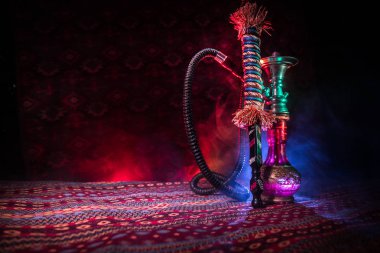 Nargile kömürü nargile kupa Arap iç de buhar bulutları yapma. Şark süsleme halı üzerinde. Şık oryantal shisha içinde karanlık arka ışık ile. Shisha reklam için. Seçici odak