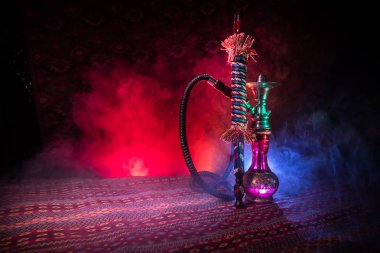 Nargile kömürü nargile kupa Arap iç de buhar bulutları yapma. Şark süsleme halı üzerinde. Şık oryantal shisha içinde karanlık arka ışık ile. Shisha reklam için. Seçici odak