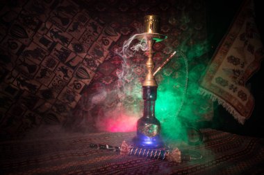 Nargile kömürü nargile kupa Arap iç de buhar bulutları yapma. Şark süsleme halı üzerinde. Şık oryantal shisha içinde karanlık arka ışık ile. Shisha reklam için. Seçici odak