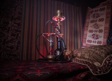 Nargile kömürü nargile kupa Arap iç de buhar bulutları yapma. Şark süsleme halı üzerinde. Şık oryantal shisha içinde karanlık arka ışık ile. Shisha reklam için. Seçici odak