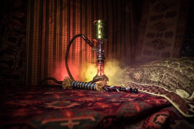 Nargile kömürü nargile kupa Arap iç de buhar bulutları yapma. Şark süsleme halı üzerinde. Şık oryantal shisha içinde karanlık arka ışık ile. Shisha reklam için. Seçici odak