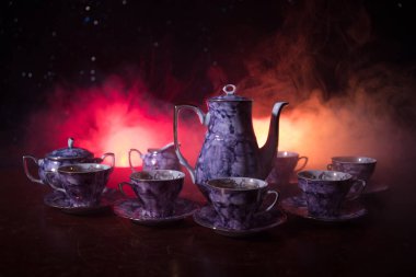 Kahve veya çay töreni kavramsal tema. Eski vintage Seramik çay veya kahve koyu tonlu arka plan ışık ve duman ile bardak sürahi ve şeker Kupası ile. Metin için boş yer. Seçici odak