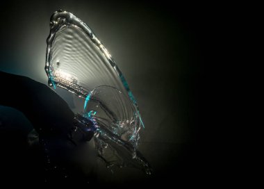 Martini kokteyl cam el koyu tonda dumanlı arka plan veya renkli kokteyl cam su sıçramalarına ve zeytin sıçramasına. Parti club eğlence. Karışık ışık. Seçici odak