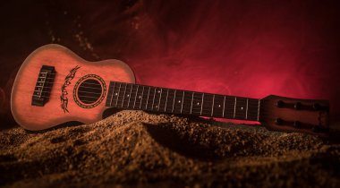 Müzik konsepti. Akustik gitar ile kopya alanı dumanla ışık demeti altında karanlık bir arka plan üzerinde izole. Gitar telleri, yakın çekim. Seçici odak.
