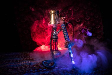 Nargile kömürü nargile kupa Arap iç de buhar bulutları yapma. Şark süsleme halı üzerinde. Şık oryantal shisha içinde karanlık arka ışık ile. Shisha reklam için. Seçici odak