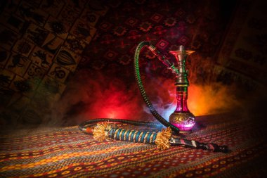 Nargile kömürü nargile kupa Arap iç de buhar bulutları yapma. Şark süsleme halı üzerinde. Şık oryantal shisha içinde karanlık arka ışık ile. Shisha reklam için. Seçici odak