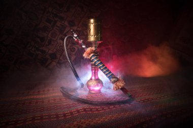 Nargile kömürü nargile kupa Arap iç de buhar bulutları yapma. Şark süsleme halı üzerinde. Şık oryantal shisha içinde karanlık arka ışık ile. Shisha reklam için. Seçici odak