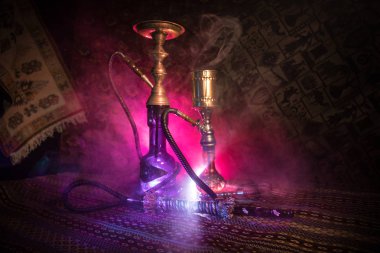 Nargile kömürü nargile kupa Arap iç de buhar bulutları yapma. Şark süsleme halı üzerinde. Şık oryantal shisha içinde karanlık arka ışık ile. Shisha reklam için. Seçici odak