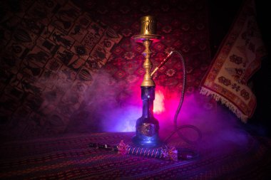Nargile kömürü nargile kupa Arap iç de buhar bulutları yapma. Şark süsleme halı üzerinde. Şık oryantal shisha içinde karanlık arka ışık ile. Shisha reklam için. Seçici odak