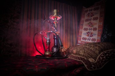Nargile kömürü nargile kupa Arap iç de buhar bulutları yapma. Şark süsleme halı üzerinde. Şık oryantal shisha içinde karanlık arka ışık ile. Shisha reklam için. Seçici odak