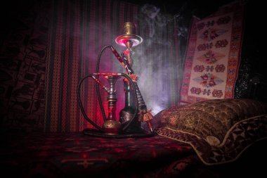 Nargile kömürü nargile kupa Arap iç de buhar bulutları yapma. Şark süsleme halı üzerinde. Şık oryantal shisha içinde karanlık arka ışık ile. Shisha reklam için. Seçici odak