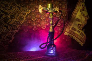 Nargile kömürü nargile kupa Arap iç de buhar bulutları yapma. Şark süsleme halı üzerinde. Şık oryantal shisha içinde karanlık arka ışık ile. Shisha reklam için. Seçici odak