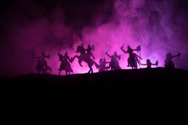 Süvari ve piyade ile ortaçağ savaş sahnesi. Siluetleri şekiller ayrı nesneler olarak mücadele koyu tonda sisli arka plan savaşçılar arasında. Gece sahne. Seçici odak