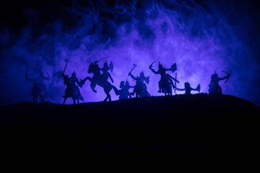 Süvari ve piyade ile ortaçağ savaş sahnesi. Siluetleri şekiller ayrı nesneler olarak mücadele koyu tonda sisli arka plan savaşçılar arasında. Gece sahne. Seçici odak