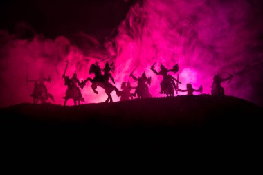 Süvari ve piyade ile ortaçağ savaş sahnesi. Siluetleri şekiller ayrı nesneler olarak mücadele koyu tonda sisli arka plan savaşçılar arasında. Gece sahne. Seçici odak