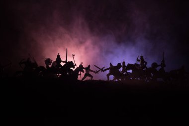 Süvari ve piyade ile ortaçağ savaş sahnesi. Siluetleri şekiller ayrı nesneler olarak mücadele koyu tonda sisli arka plan savaşçılar arasında. Gece sahne. Seçici odak