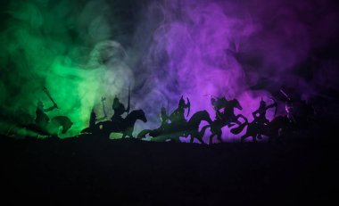 Süvari ve piyade ile ortaçağ savaş sahnesi. Siluetleri şekiller ayrı nesneler olarak mücadele koyu tonda sisli arka plan savaşçılar arasında. Gece sahne. Seçici odak