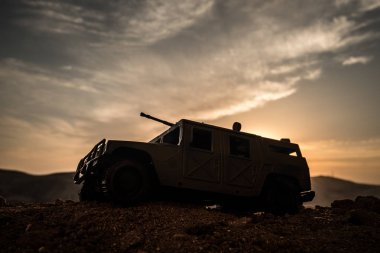 Gün batımı arka plan üzerinde askeri devriye arabası. Ordu savaş kavramı. Eylemde silahlı ve zırhlı silüeti. Dekore edilmiş. Seçici odak