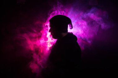 Bir mod tutarak Vaping adam. Buhar bulutu. karanlık sisli bulutlar duman arka plan tonda. Vaping elektronik sigara duman bir sürü ile. Vape kavramı. Seçici odak