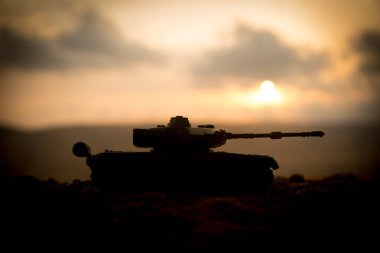 Savaş kavramı. Askeri savaş sis gökyüzü arka plan, Dünya Savaşı askerler siluetleri aşağıda bulutlu manzarası gün batımında dövüş sahnesinde siluetleri. Saldırı sahne. Zırhlı araçlar. tank içinde hareket