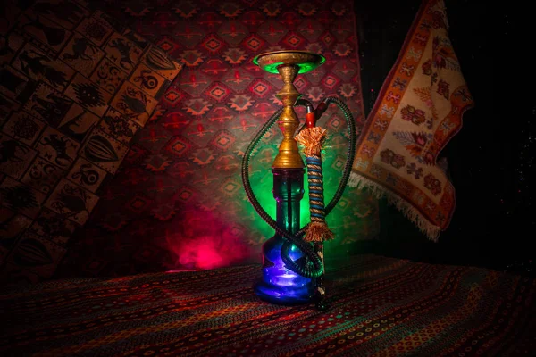 Nargile kömürü nargile kupa Arap iç de buhar bulutları yapma. Şark süsleme halı üzerinde. Şık oryantal shisha içinde karanlık arka ışık ile. Shisha reklam için. Seçici odak