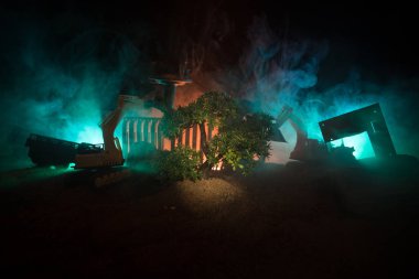 Ormansızlaşma ve orman. Ekskavatör orman kaldırdıktan sonra ağaç kütükleri ve kökleri kazıp çıkarırdı. Sis masa dekorasyonu ile koyu tonda. Kavramsal. Seçici odak