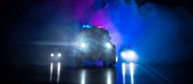 Geceleri polis arabaları. Polis arabası sisli bir arabayı gece takip ediyor. 911 acil durum arabası suç mahalline doğru hızla gidiyor. Seçici odak