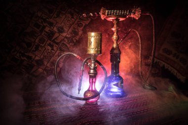 Nargile kömürü nargile kupa Arap iç de buhar bulutları yapma. Şark süsleme halı üzerinde. Şık oryantal shisha içinde karanlık arka ışık ile. Shisha reklam için. Seçici odak