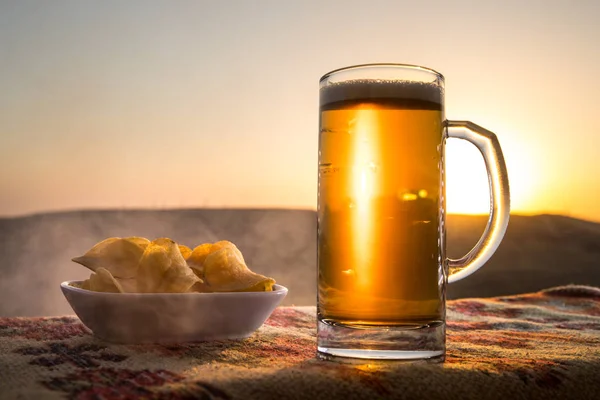 Close Up of A Glass of Beer with the snacks on Sunlight Background. Selective focus