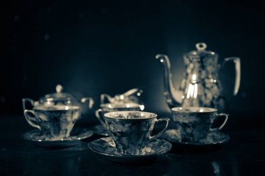 Kahve veya çay töreni kavramsal tema. Eski vintage Seramik çay veya kahve koyu tonlu arka plan ışık ve duman ile bardak sürahi ve şeker Kupası ile. Metin için boş yer. Seçici odak