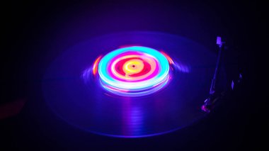 Müzik konsepti. FreezeLight parlak vinil koyu arka plan veya vinil parlayan Özet satırları konsepti ile koyu arka plan üzerinde oynarken pikap. Club poster tasarımı