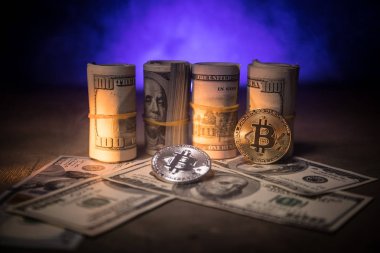 Bitcoin (sanal para) para ile toplu bize dolar koyu tonda sisli arka plan üzerinde. Seçici odak. Dijital para ve Bitcoin kavramı.