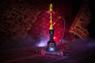 Nargile kömürü nargile kupa Arap iç de buhar bulutları yapma. Şark süsleme halı üzerinde. Şık oryantal shisha içinde karanlık arka ışık ile. Shisha reklam için. Seçici odak