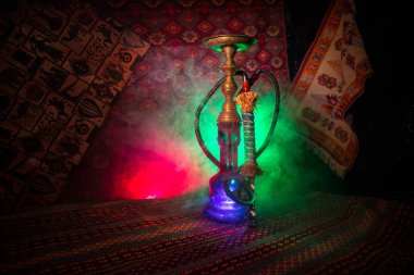 Nargile kömürü nargile kupa Arap iç de buhar bulutları yapma. Şark süsleme halı üzerinde. Şık oryantal shisha içinde karanlık arka ışık ile. Shisha reklam için. Seçici odak