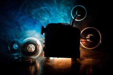 Eski stil film projektör, Natürmort, yakın çekim. Film projektör dramatik aydınlatma ve seçici odak ahşap bir zemin üzerine. Film ve eğlence kavramının