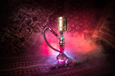 Nargile kömürü nargile kupa Arap iç de buhar bulutları yapma. Şark süsleme halı üzerinde. Şık oryantal shisha içinde karanlık arka ışık ile. Shisha reklam için. Seçici odak